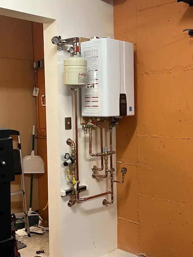Plumbing technician inspecting water heater connections in Hibbing